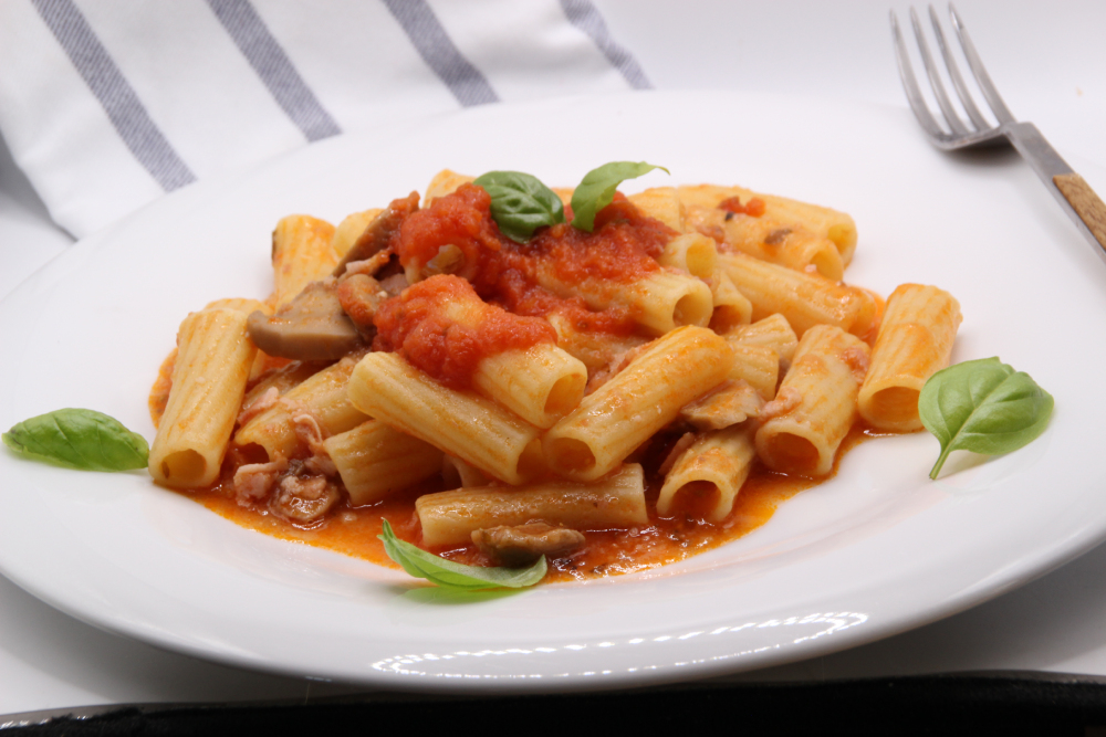 Tortiglioni con bacon y champiñones